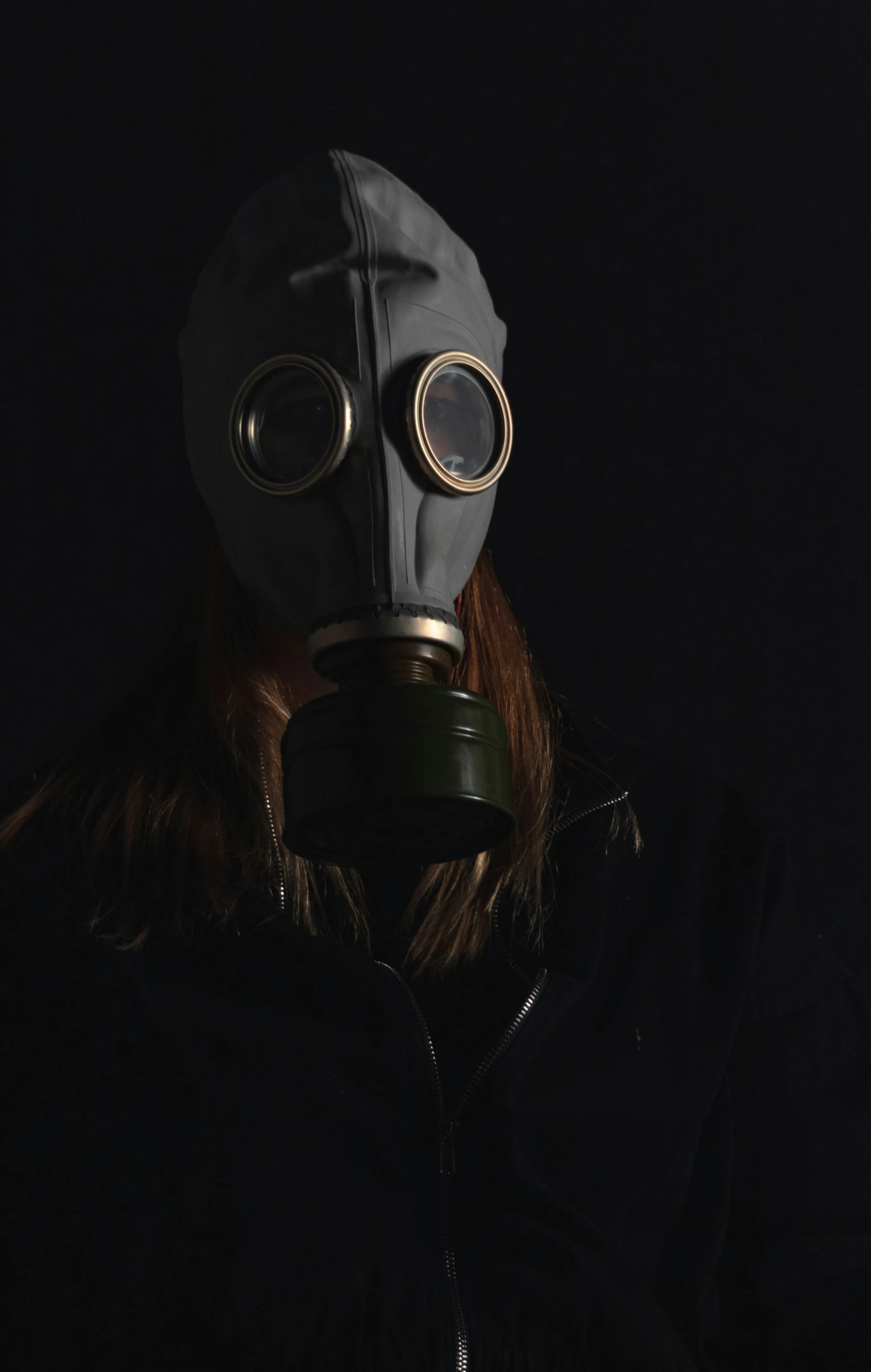 person wearing gas mask and jacket looking sideways