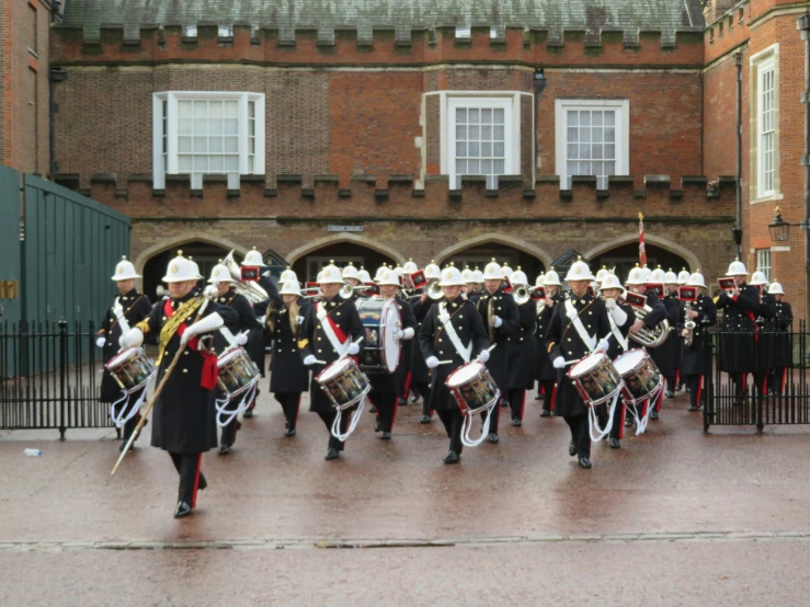 marching band with marching supplies in uniform outside an building