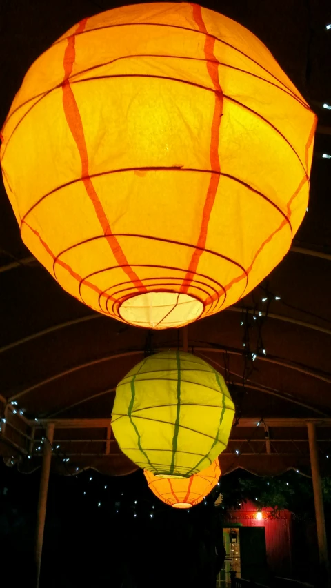 three lanterns in the middle of the dark, filled with lights