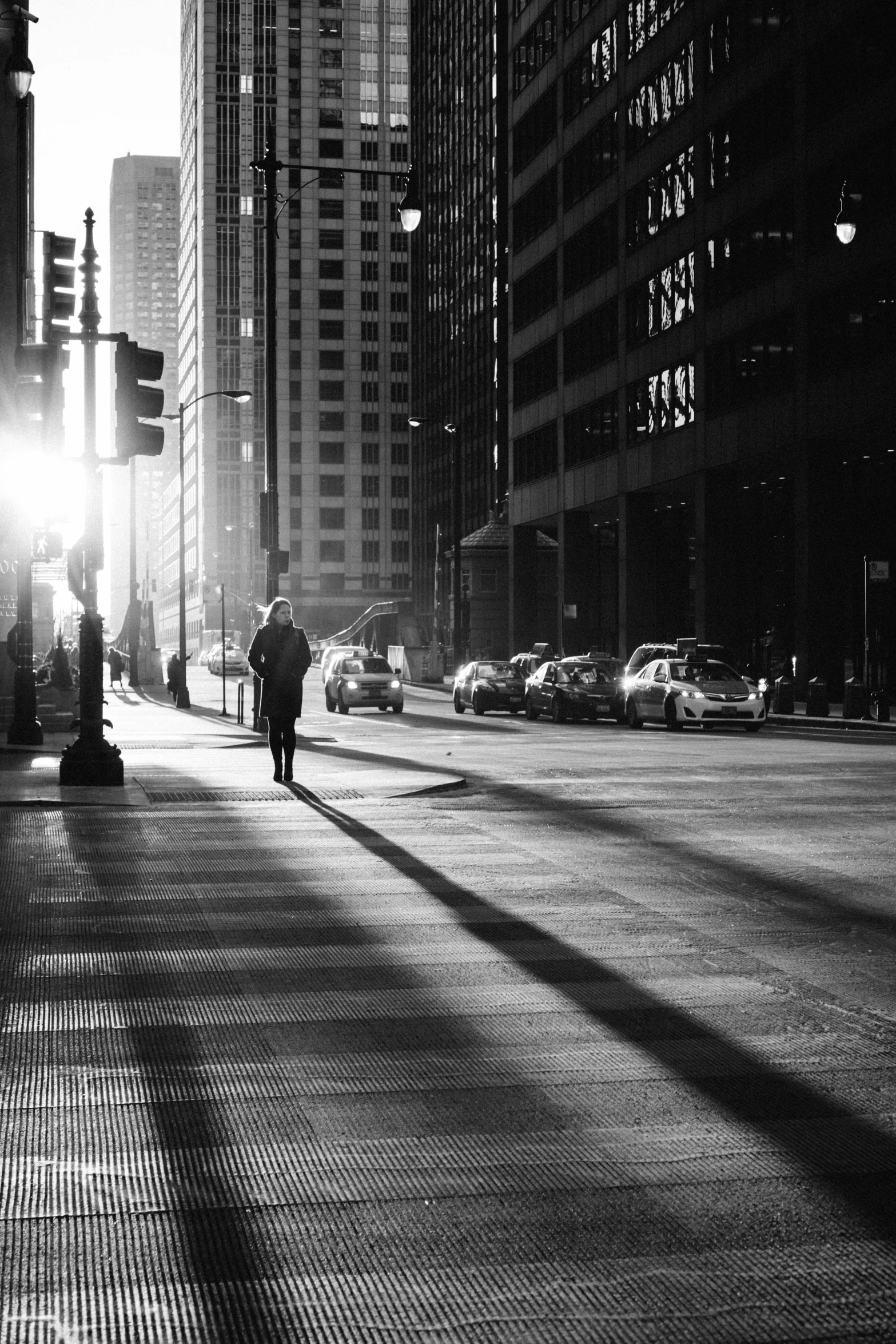 a person walking along side of tall buildings on a city street