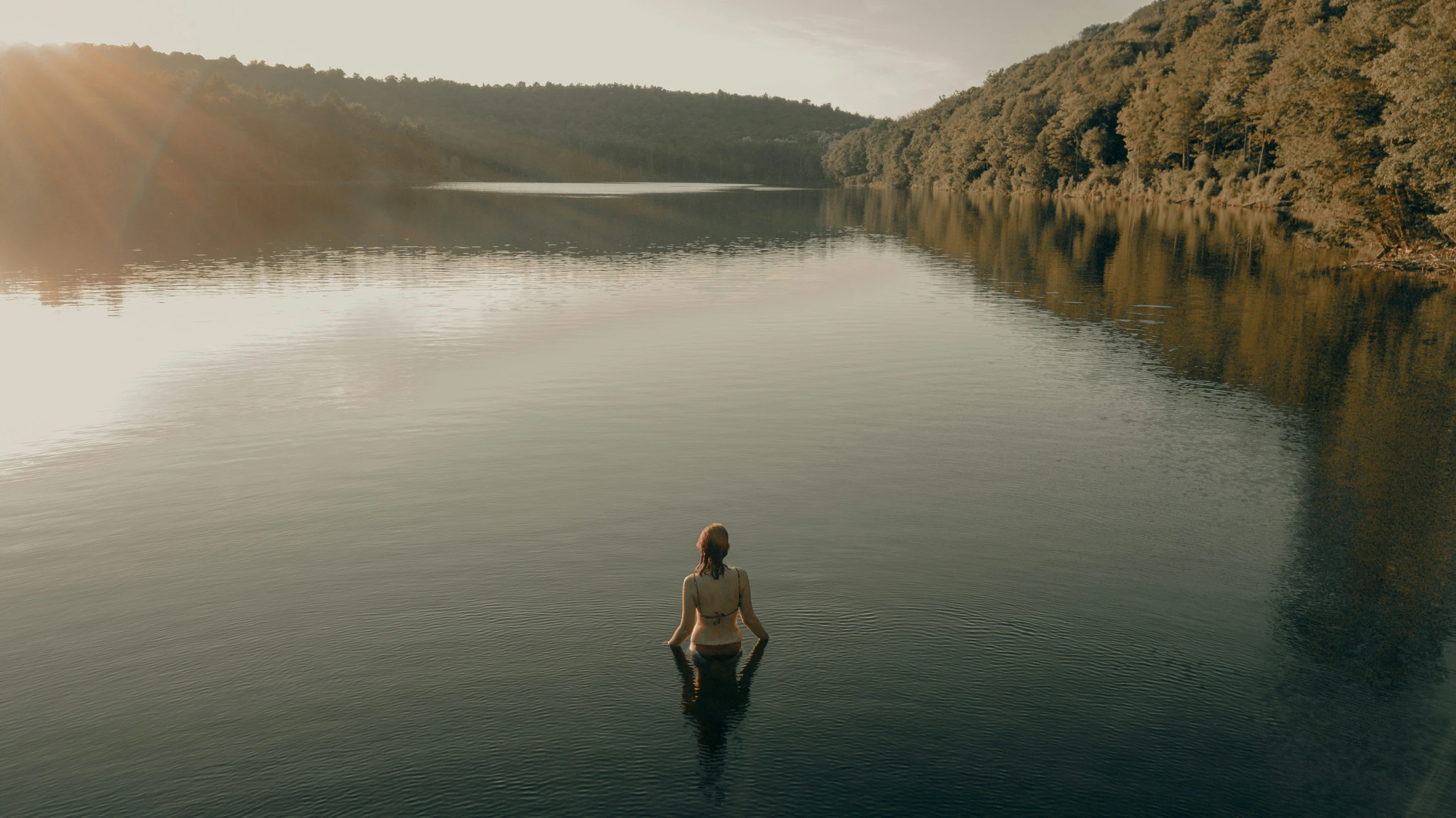 a woman sitting on a log in the water