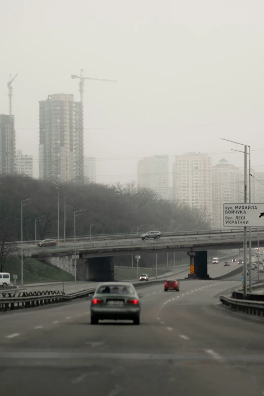 a street with cars and traffic on it with trees and buildings in the background