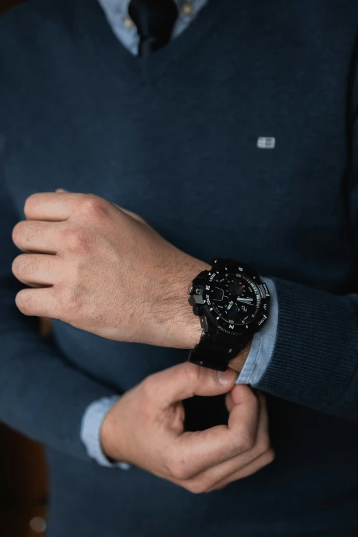 man holding onto wrist and watch while wearing dress shirt