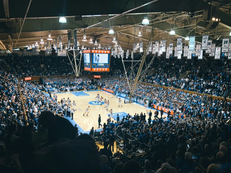 a crowd in an arena watching a basketball game