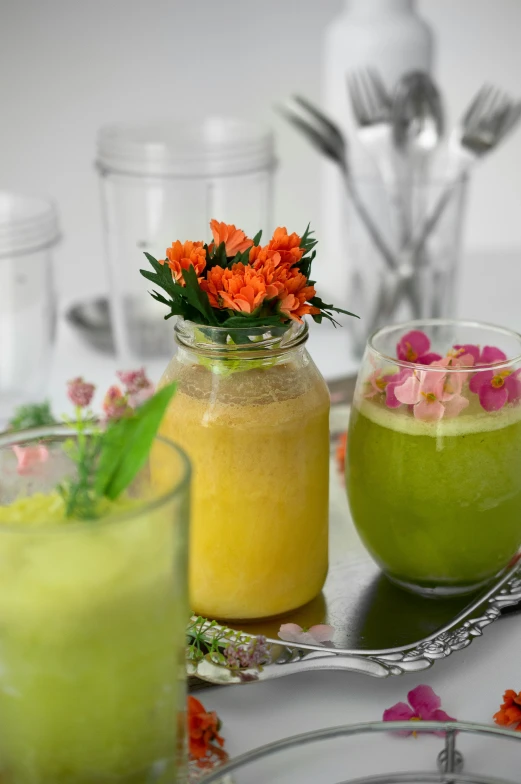 the two pitchers of drinks have orange and yellow flowers in them