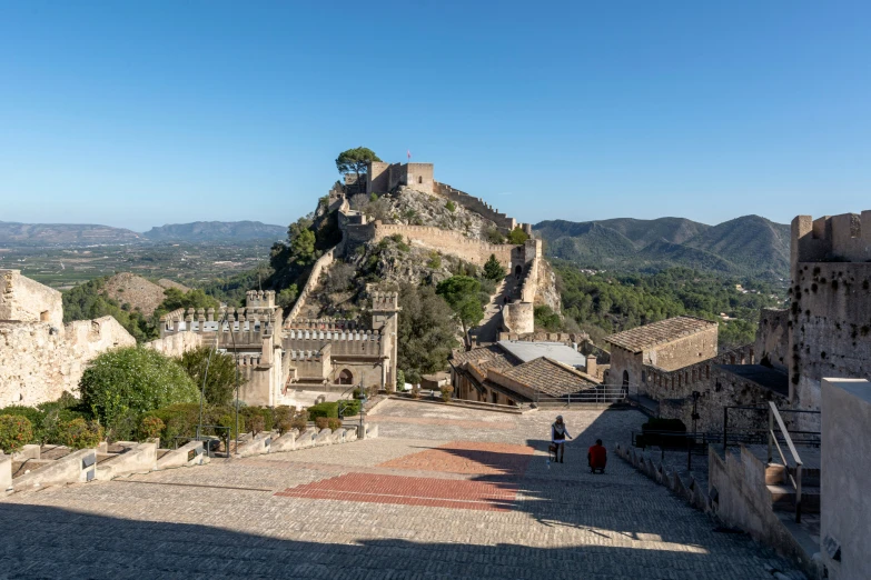 people standing on top of a very large stone castle