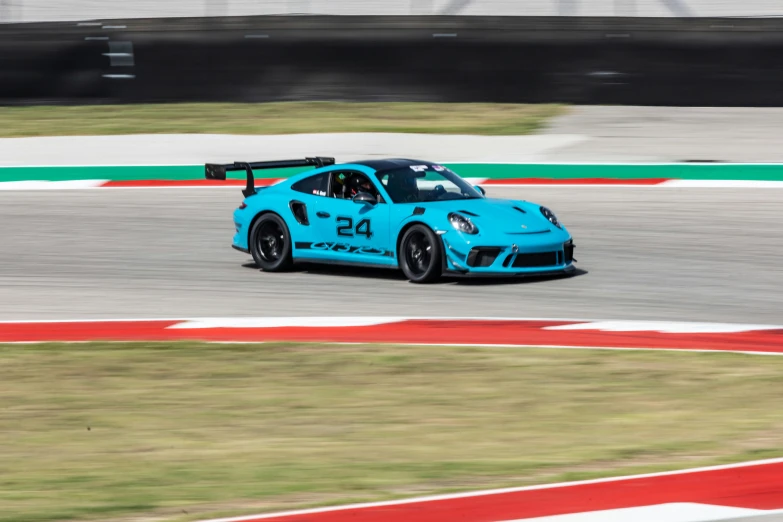 a blue car driving around a track