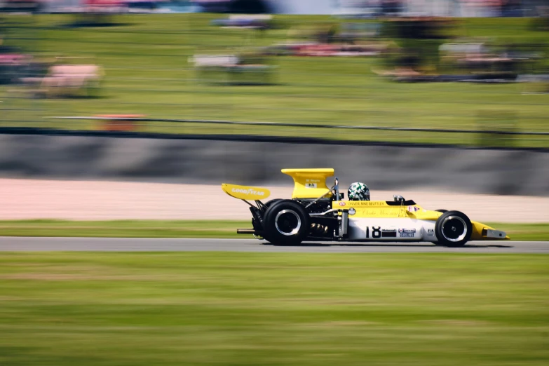 a yellow and white racing car racing along the track