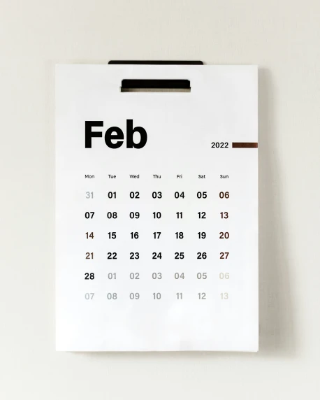 a calendar on the wall hanging with an clip