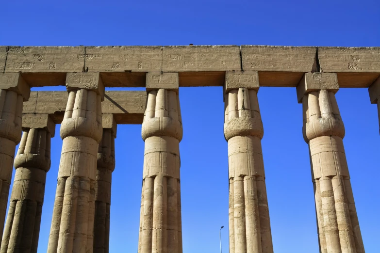 two rows of stone pillars against a bright blue sky
