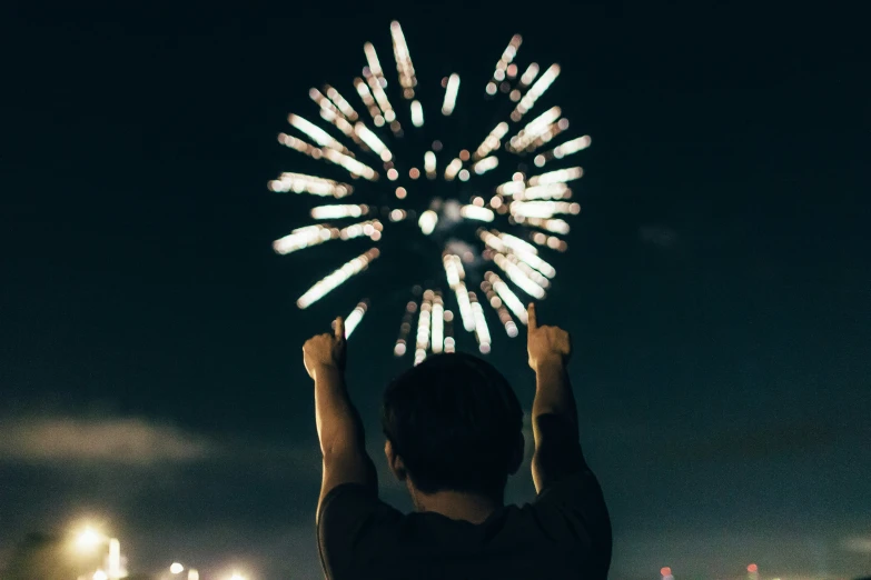 a man that is standing up with a fireworks
