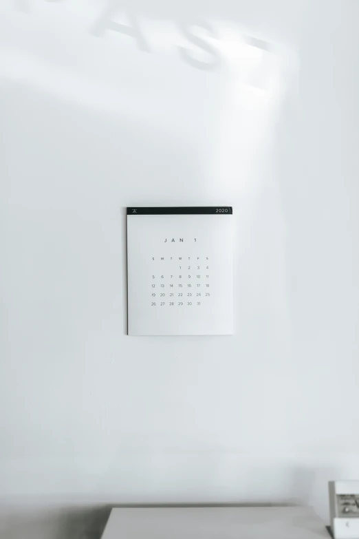 a calendar on a wall above a white shelf