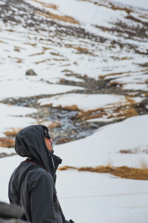 a man riding down the side of a snow covered slope