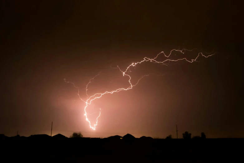 a storm hitting over a house and a lightening bolt