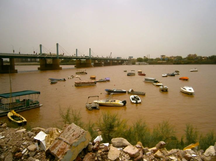 boats are on a large body of water near a bridge