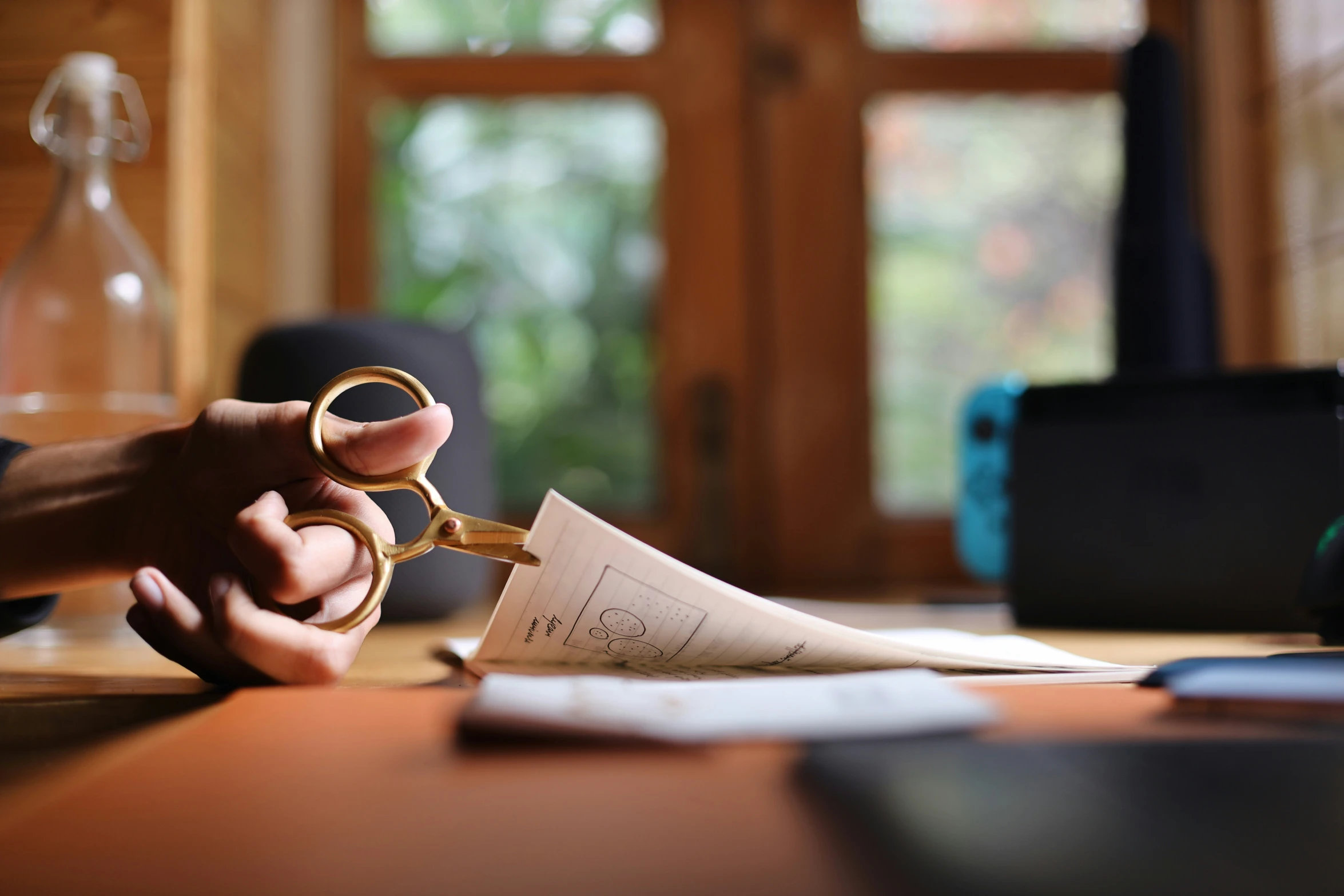 a person holds a pair of scissors above a piece of paper