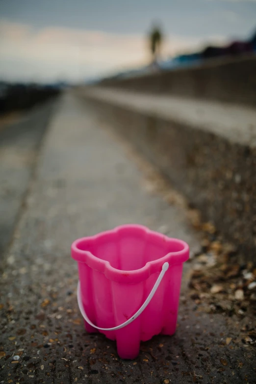 the pink bucket is on a gray surface