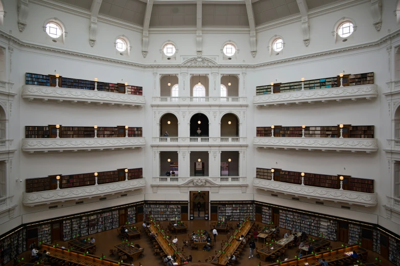 a white building has tables and books on the floor