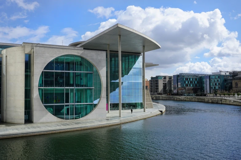 a building sitting next to a river on top of a cloudy day