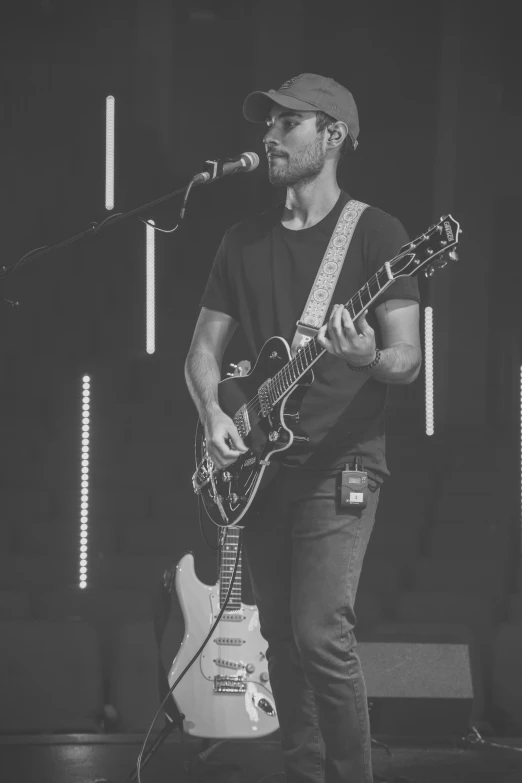 a person with a guitar and some microphones