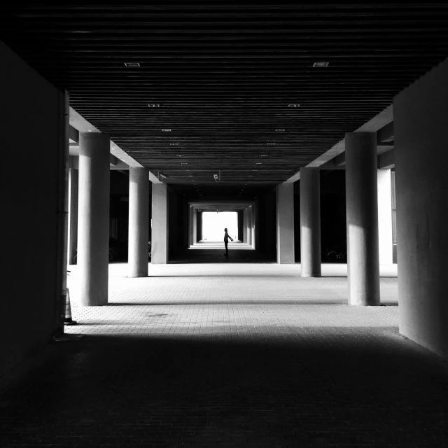 black and white pograph of man walking in a building