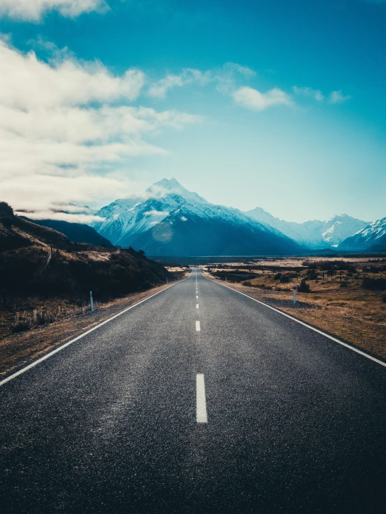 an empty road winds through the mountains with no traffic