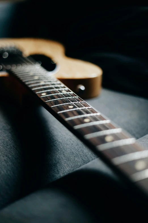 an electric guitar with its neck resting on top of a cushion