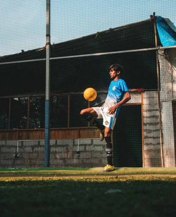 a soccer player kicks the ball with his legs