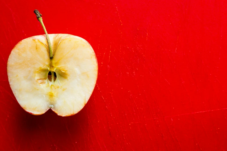 an apple against a red background that appears to have been sliced