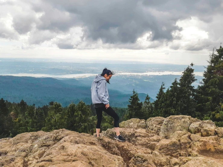 a person stands on a mountain top with trees