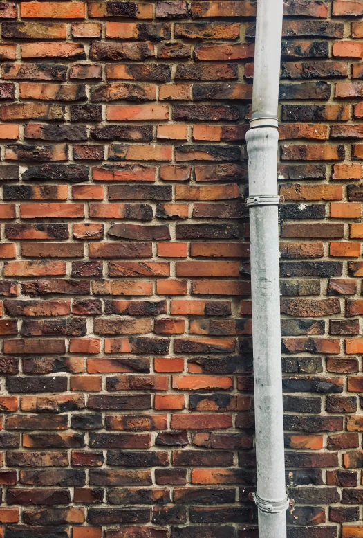 a pole against the wall is being made of bricks