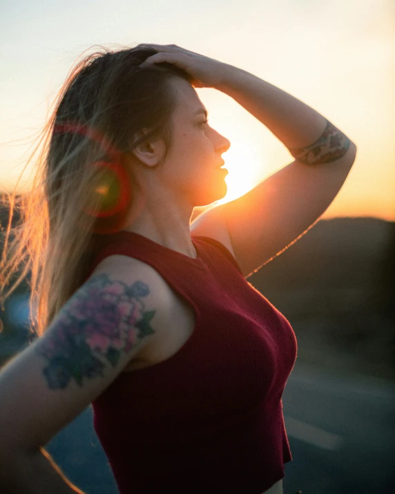 a young woman in red shirt holding her hair