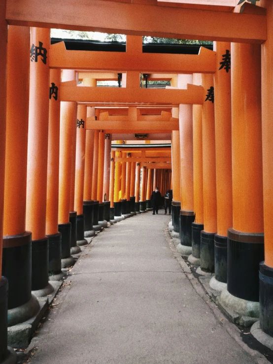 a walkway between two tall columns with one man in the center