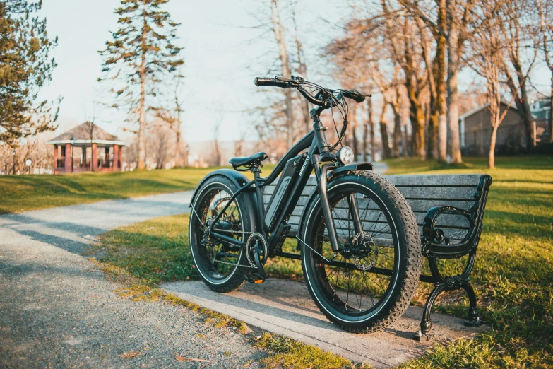 an older bike leaning against a park bench