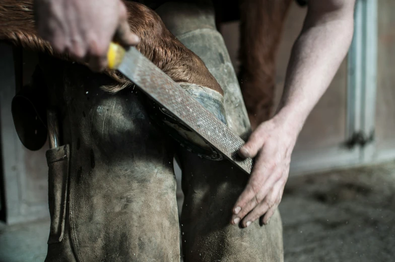 two men are using a knife to sharpe wood