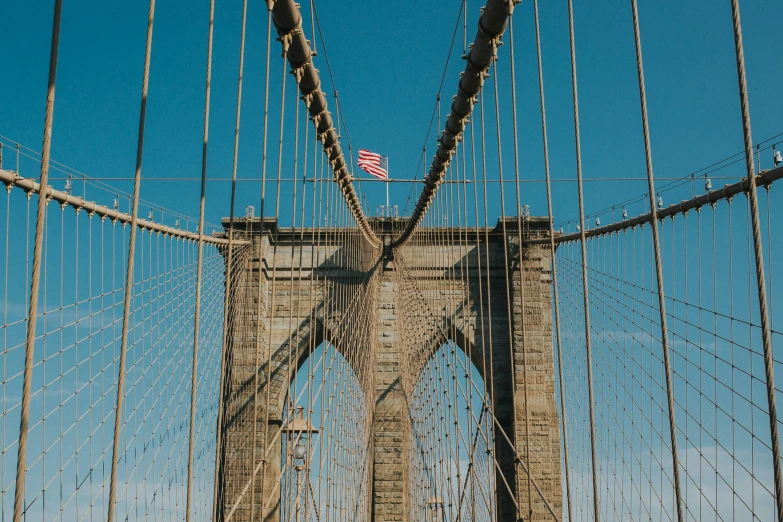 an american flag is atop a pole on top of a bridge