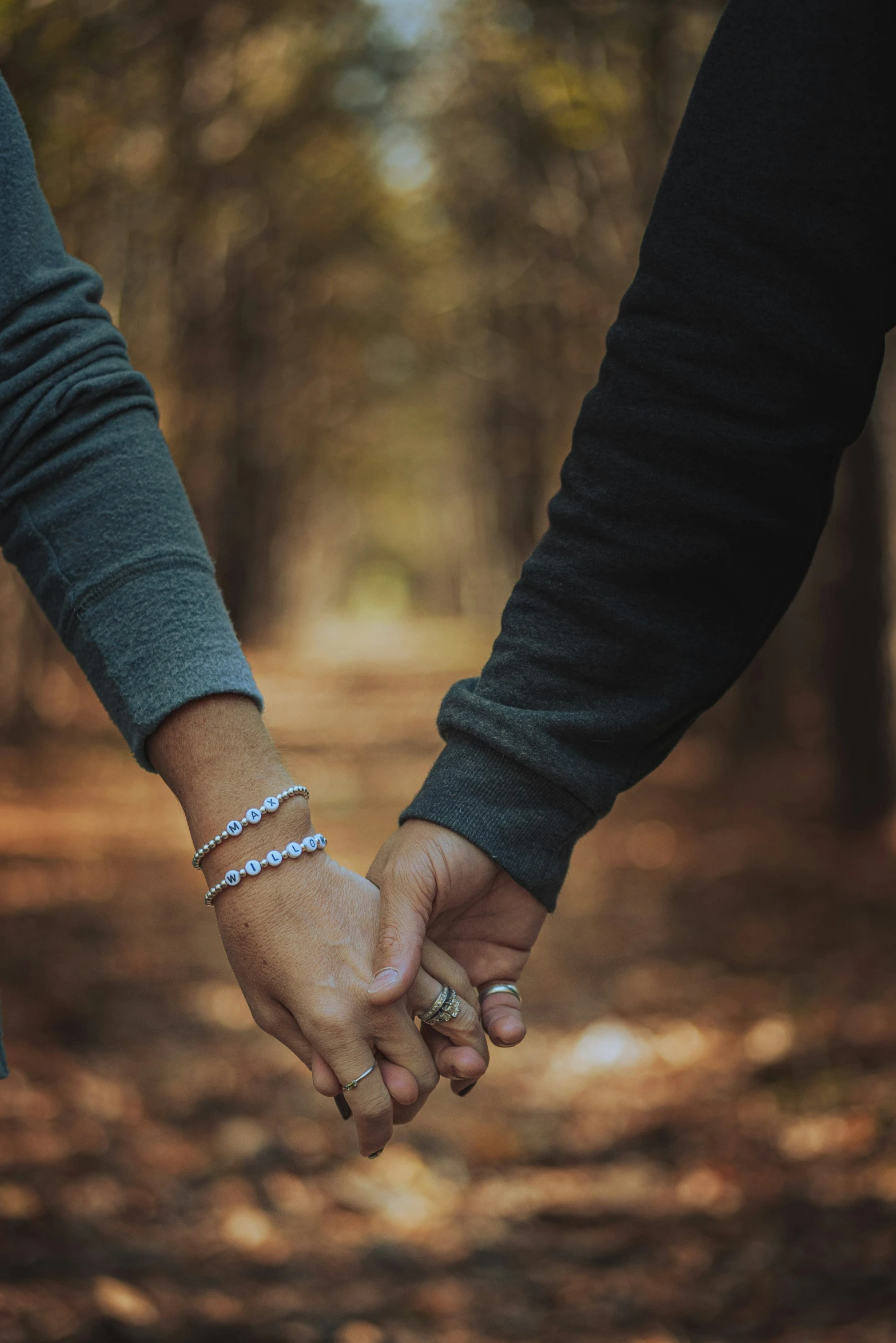 a man and woman holding hands in a forest