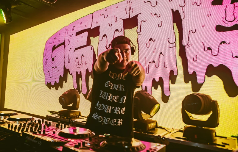 a guy in black shirt standing behind table with purple light on it