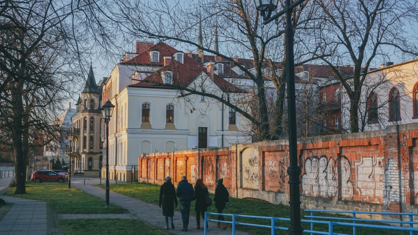 three people are walking in front of a brick building