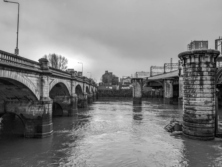 a city bridge in an empty river under a cloudy sky