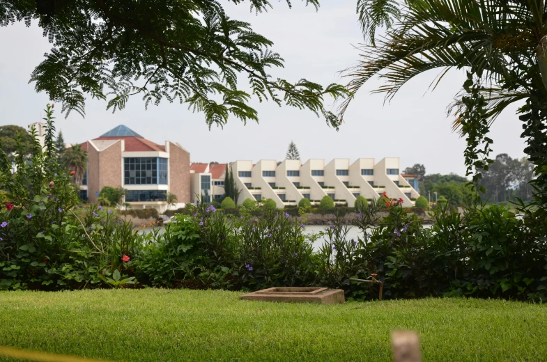 building with a lake and greenery in front of it