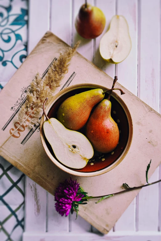 pears in a bowl next to some cut up pieces