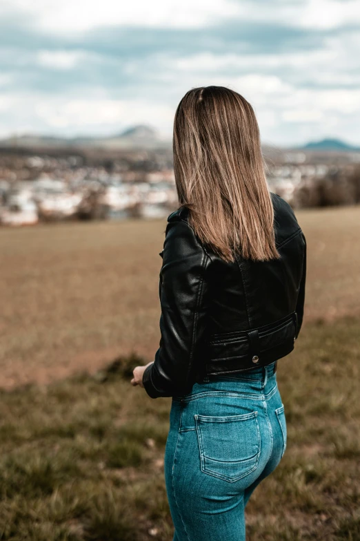 a beautiful woman is in the field, looking back