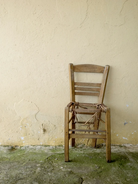 a chair sitting outside next to a wall