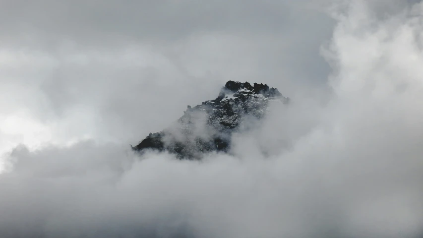 there is some clouds covering the mountain top