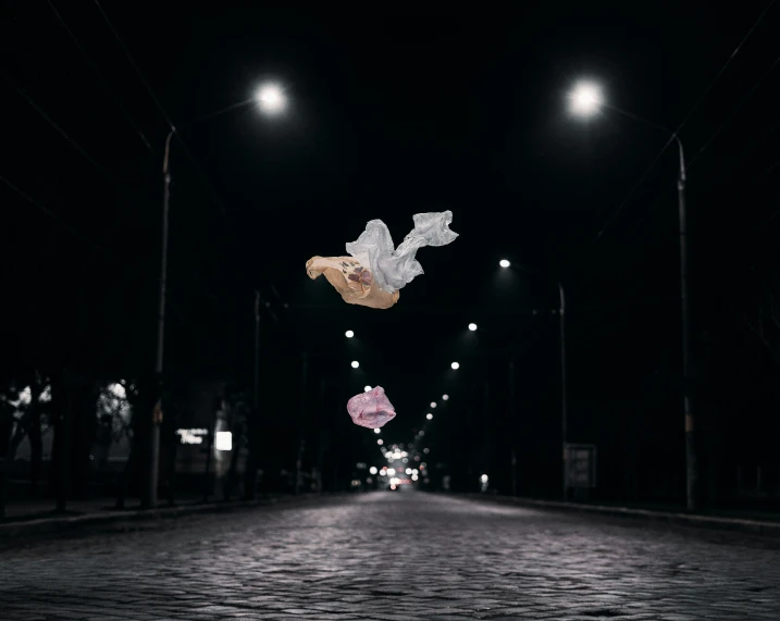 two angel wings flying over a street at night