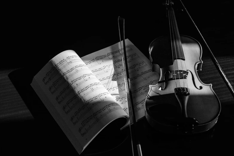 violin and sheet music pographed in black and white