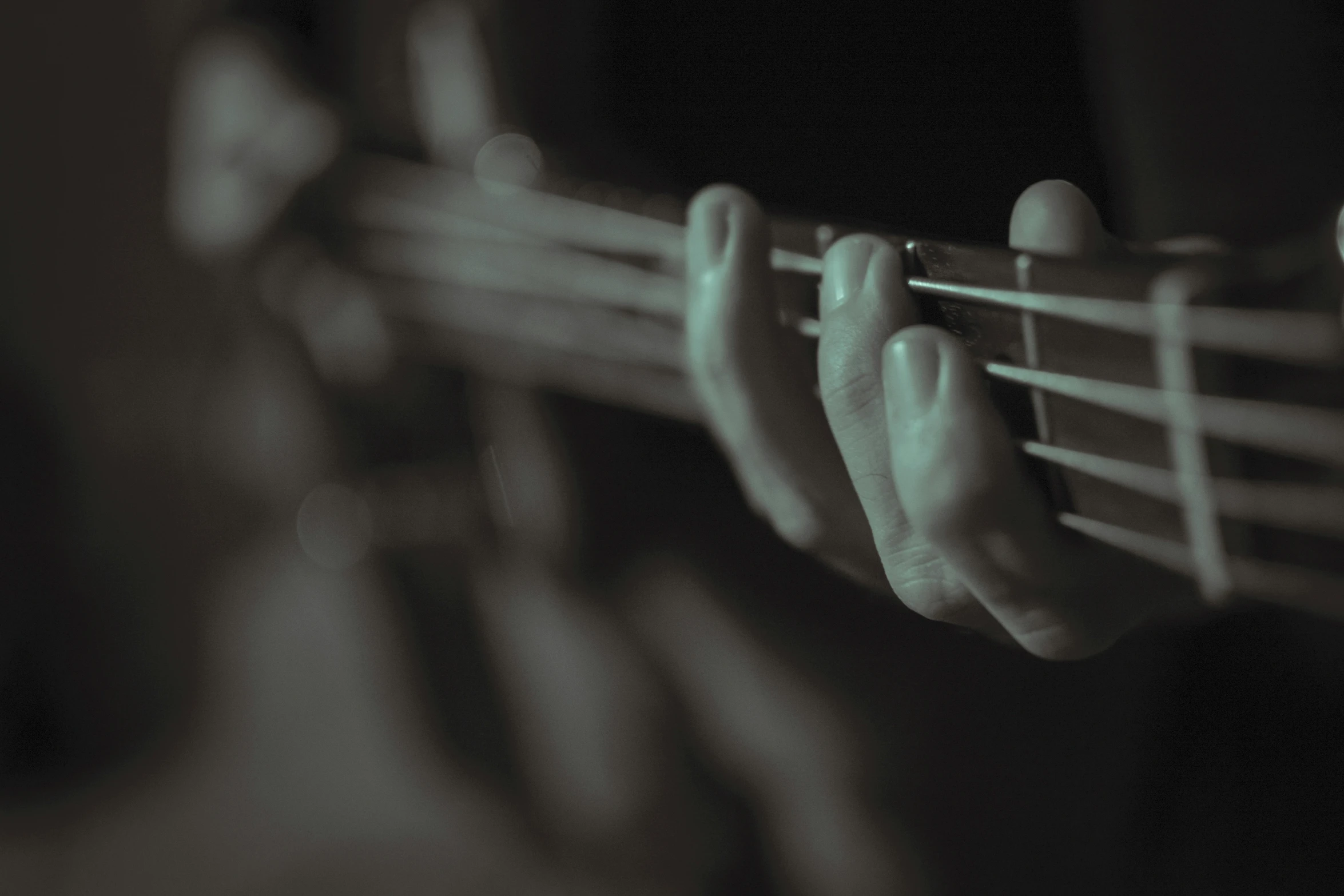 a close up view of someone's fingers and guitar strings