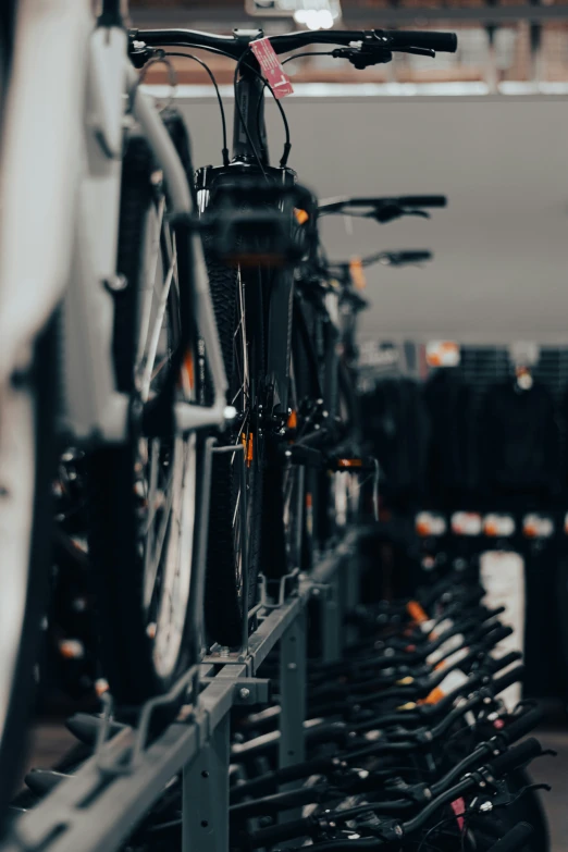 a bicycle in a bike shop, with a few bicycles lined up on the racks