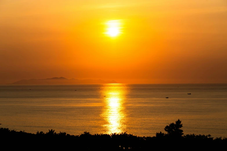 the sun shining over a lake near a shoreline